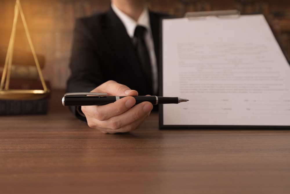 Lawyer showing document to sign by person who sued